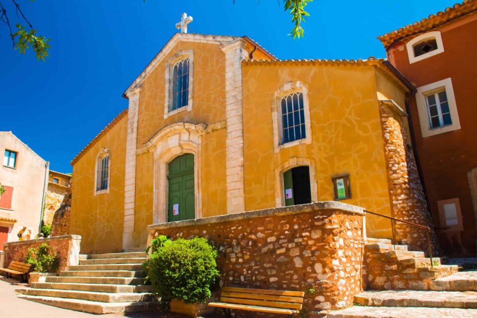 Église et maisons colorées de Roussillon aux teintes ocre caractéristiques